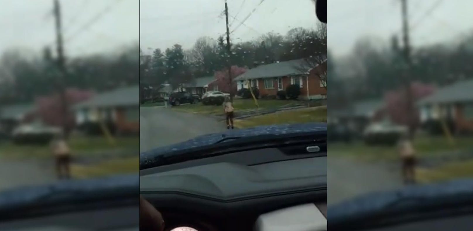 Der Zehnjährige geht im Regen, während sein Vater mit dem Auto hinten nach fährt.